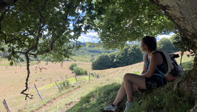 Femme randonneuse explorant les vastes plateaux d'Aubrac en Occitanie