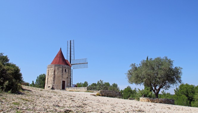 Moulin à vent provençal sur une colline de garrigue sous un ciel bleu, Moulin de Daudet