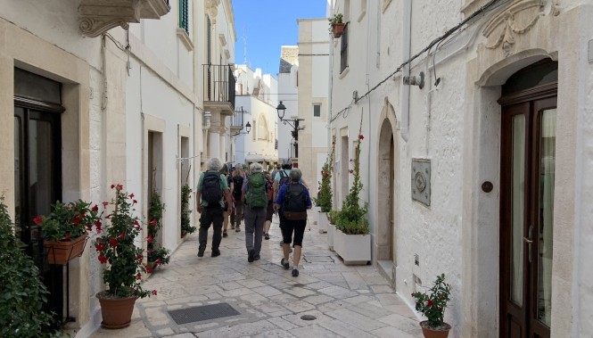 randonneurs dans une ruelle blanche d’un village des Pouilles en Italie