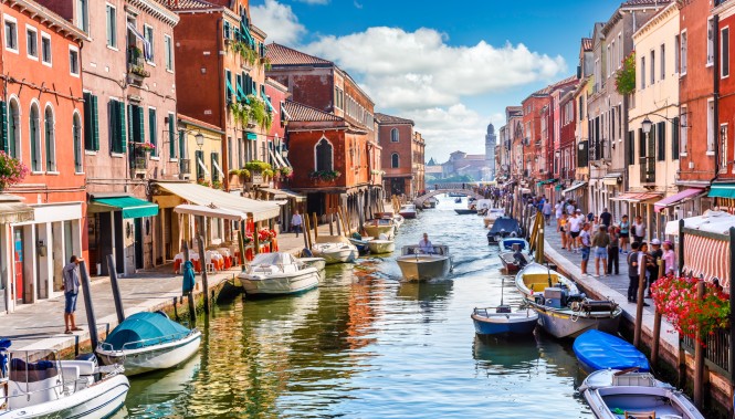 Canal coloré avec bateaux et passants à Murano, Venise, Italie