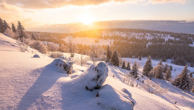 Vue sur une paysage enneigé depuis le Noirmont dans le Jura au lever du soleil
