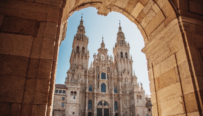 Cathédrale de Saint-Jacques-de-Compostelle vue depuis une arche en pierre chemin de Compostelle Espagne
