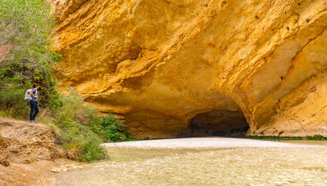 Randonneuse près d'une grotte et du Rio Vero Randonneuse dans une grotte du rio vero dans la sierra de Guara